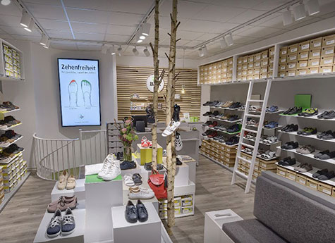 Innenansicht eines modernen Schuhladens mit vielen verschiedenen Schuhmodellen und stilvoller Einrichtung