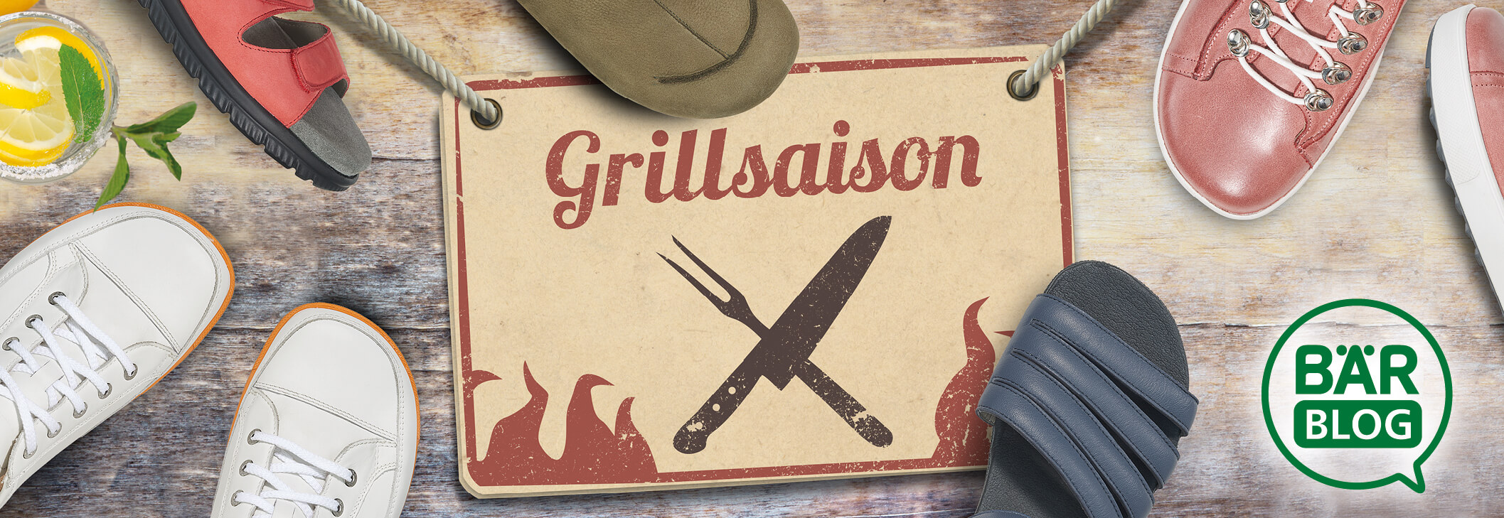 Verschiedene Schuhe und ein Schild mit der Aufschrift 'Grillsaison' auf Holzhintergrund.