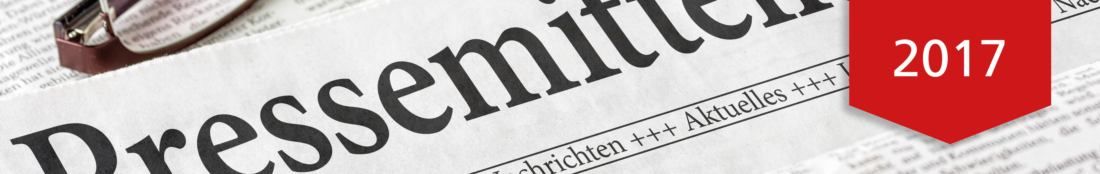Nahaufnahme einer Zeitung mit dem Wort 'Pressemitteilung' und einem roten Banner mit der Jahreszahl 2017