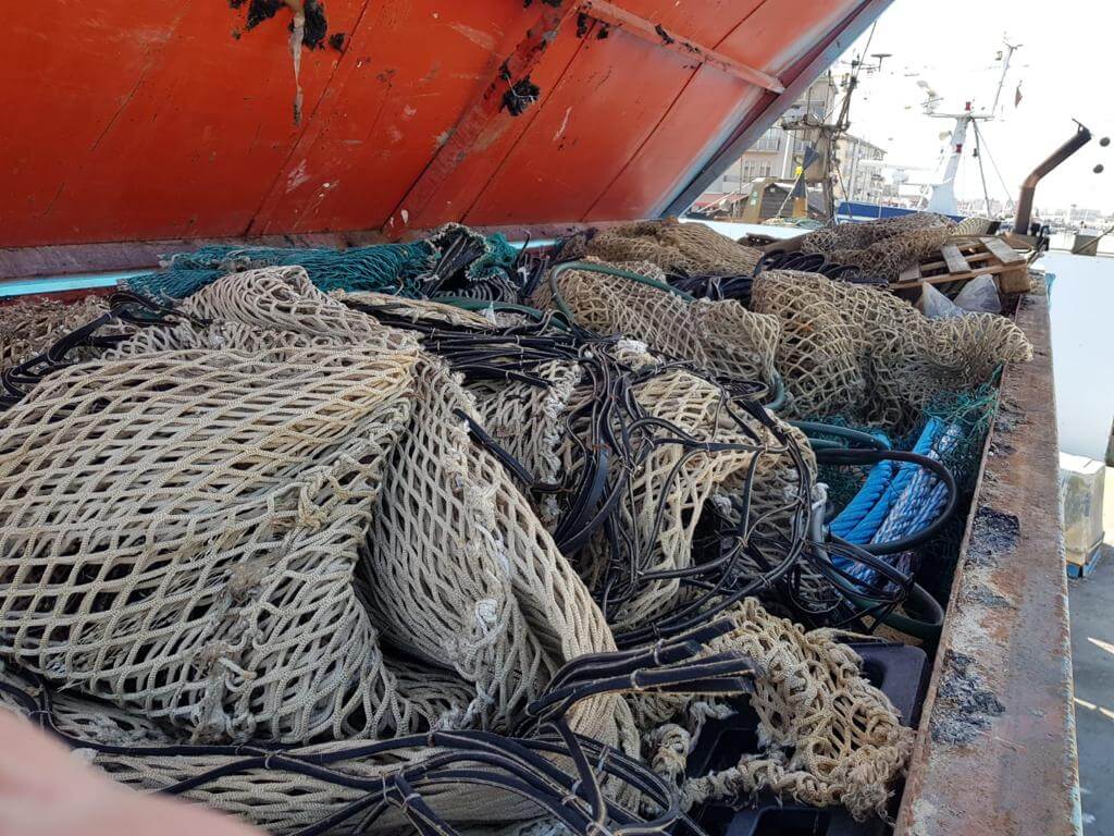 Verschiedene Fischernetze und Seile auf dem Deck eines Fischerbootes im Hafen