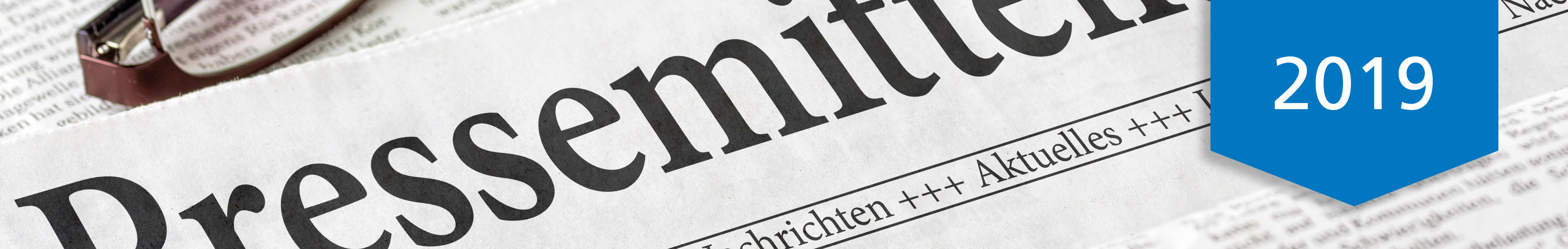 Eine Pressemitteilung aus dem Jahr 2019, abgebildet auf einer Zeitung mit einer Brille am Rand