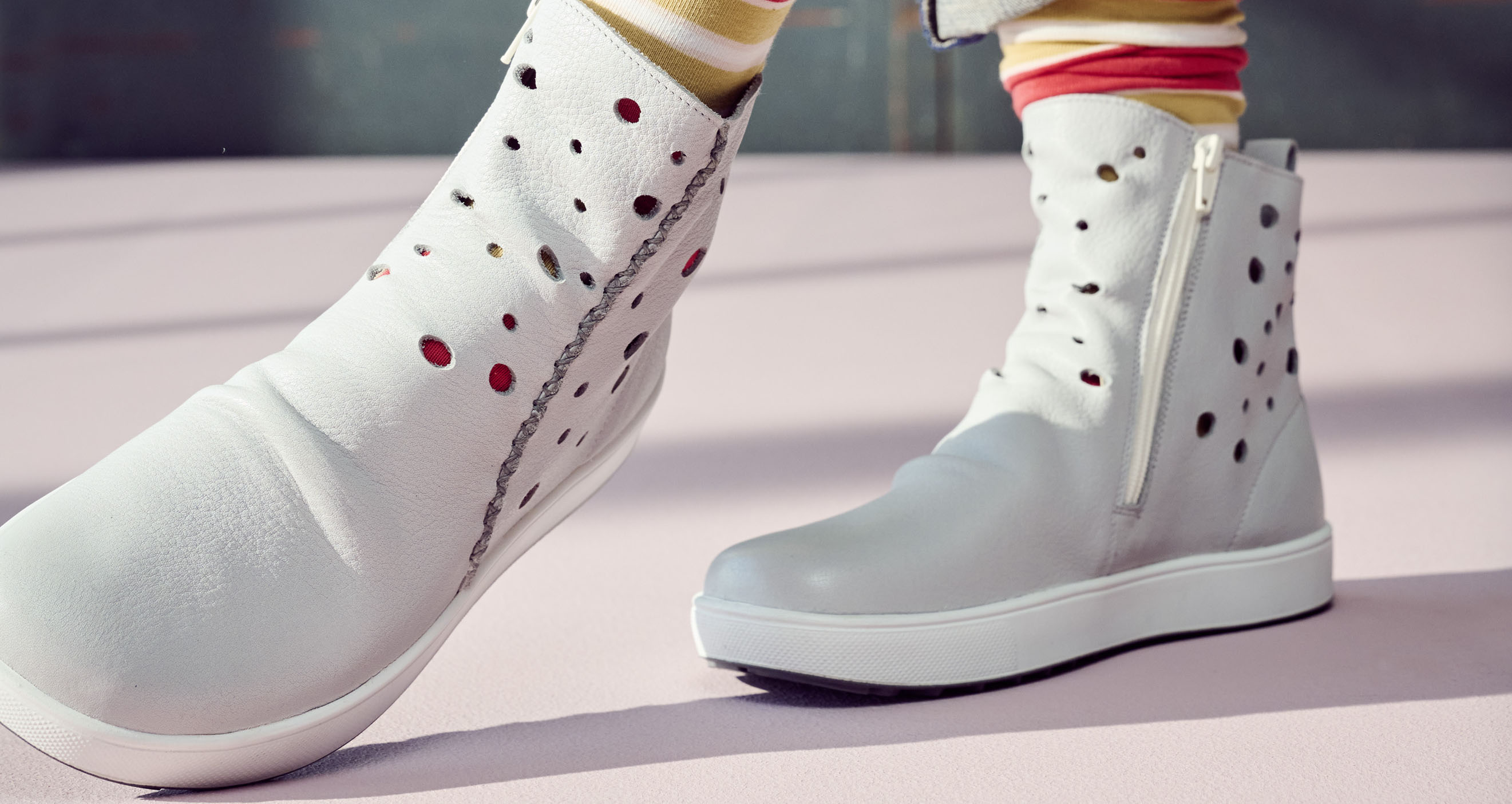 Moderne weiße Stiefeletten mit dekorativen Löchern und Reißverschluss