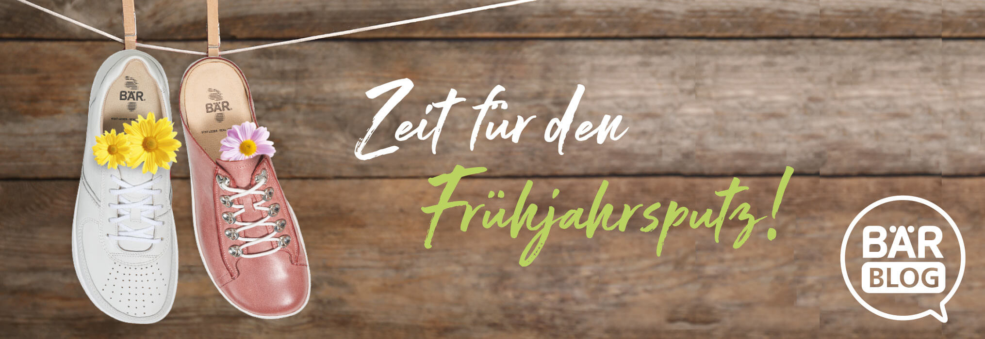 Zwei BÄR-Schuhe, verziert mit Blumen, hängen an einer Leine vor Holzhintergrund, mit dem Text 'Zeit für den Frühjahrsputz'.