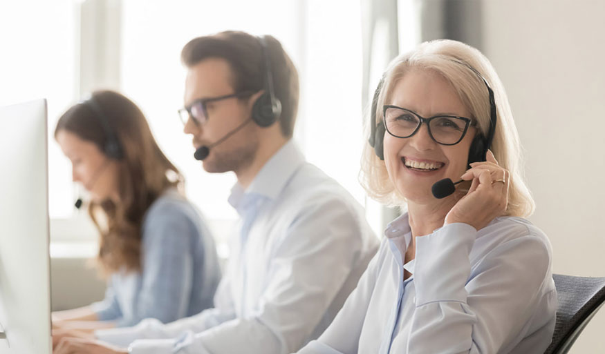 Drei Personen im Kundensupport mit Headsets, die an Computern arbeiten