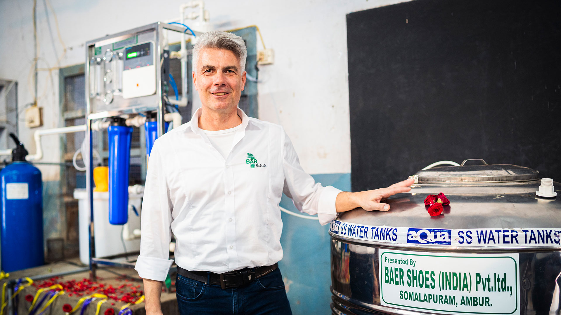 Ein Mann steht in einem technischen Raum und lehnt sich an einen Edelstahltank, der von Baer Shoes gesponsert wurde.