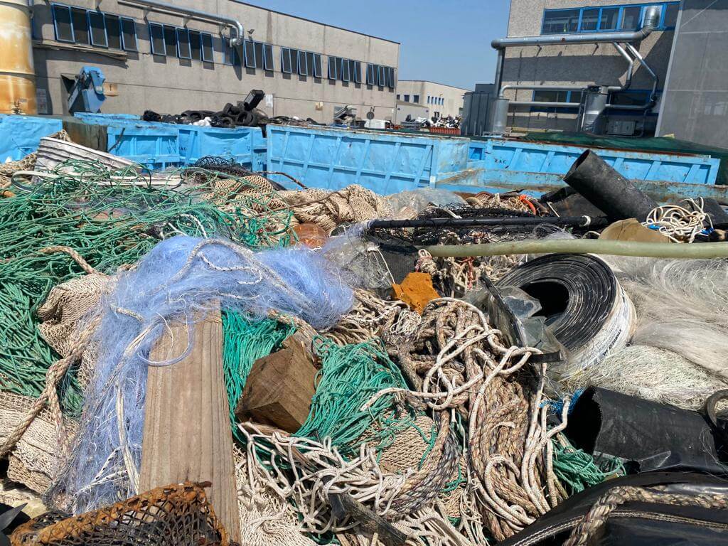 Sammlung von Netzen und Materialien zur Wiederverwertung auf einem Industriegelände bei sonnigem Wetter