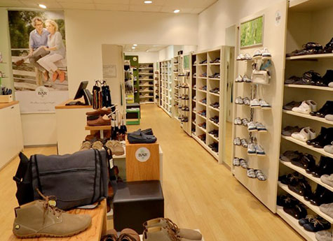 Innenansicht eines modernen Schuhgeschäfts mit Regalen voller Schuhe und einer gemütlichen Atmosphäre