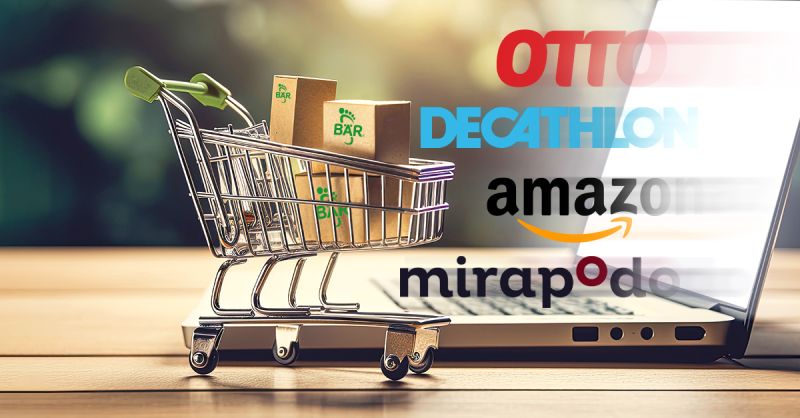Ein kleiner Einkaufswagen mit Paketen steht vor einem Laptop. Im Hintergrund sind Logos populärer Online-Shops wie Otto, Decathlon, Amazon und Mirapodo zu sehen.