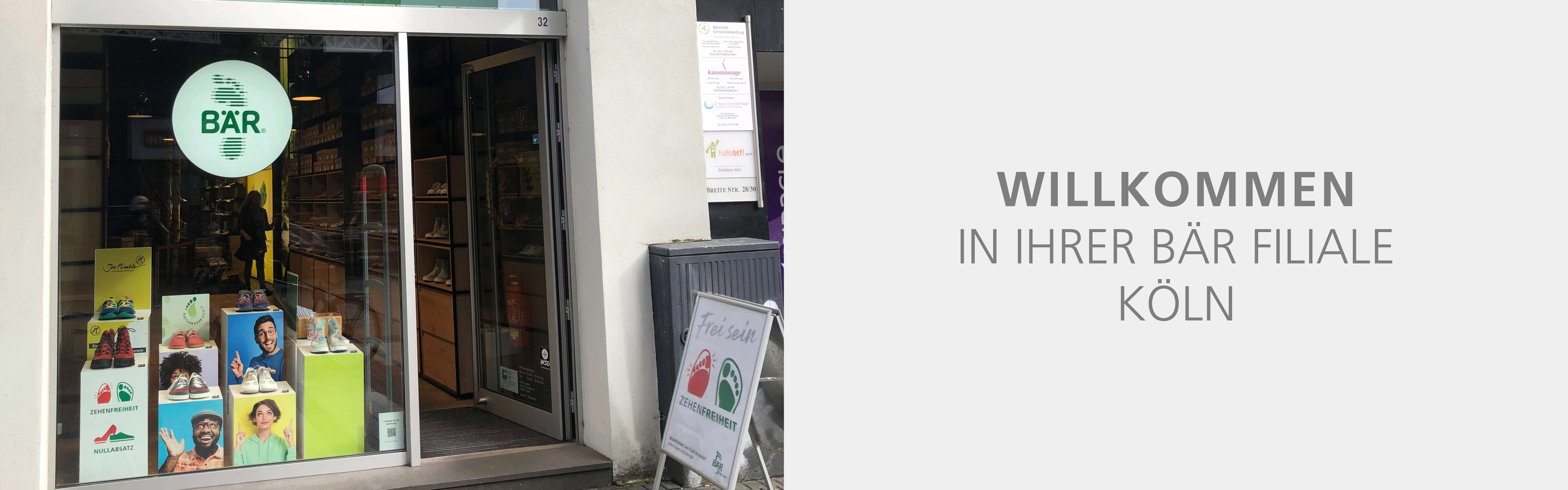 Schaufenster der BÄR Filiale in Köln, dekoriert mit diversen Schuhen und Werbebannern, Eingangstür offen.